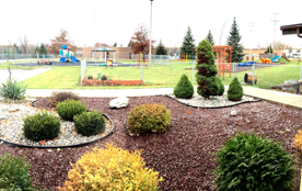 The fenced play yard and landscaped grounds at the center